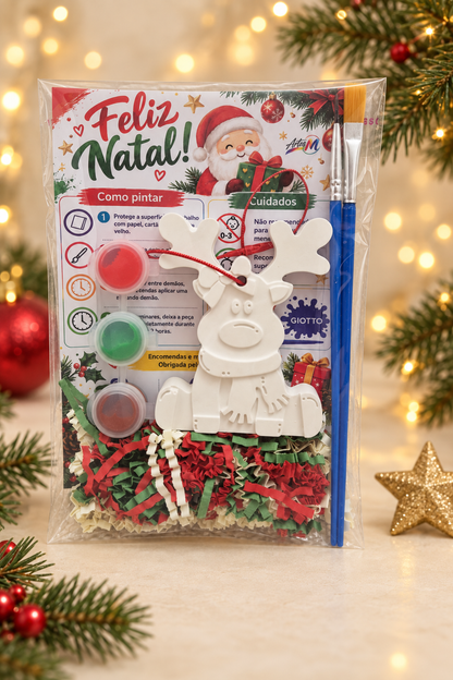Kit de Natal Artes M com rena de gesso branca com cachecol, três tintas e dois pincéis em embalagem transparente.
